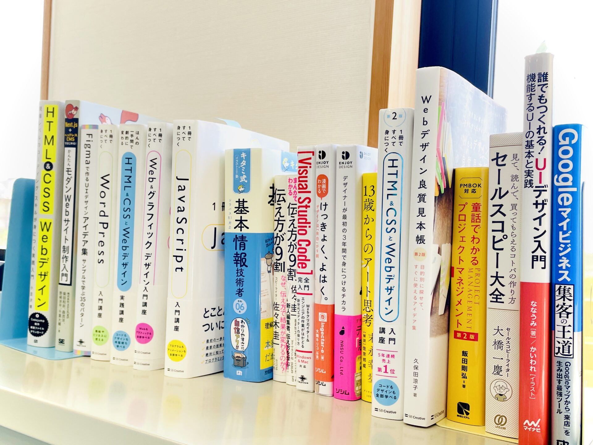 社内の技術書ライブラリ。HTML/CSS、JavaScript、Webデザイン、UI設計、プロジェクトマネジメントなど幅広い書籍が並んでいます。